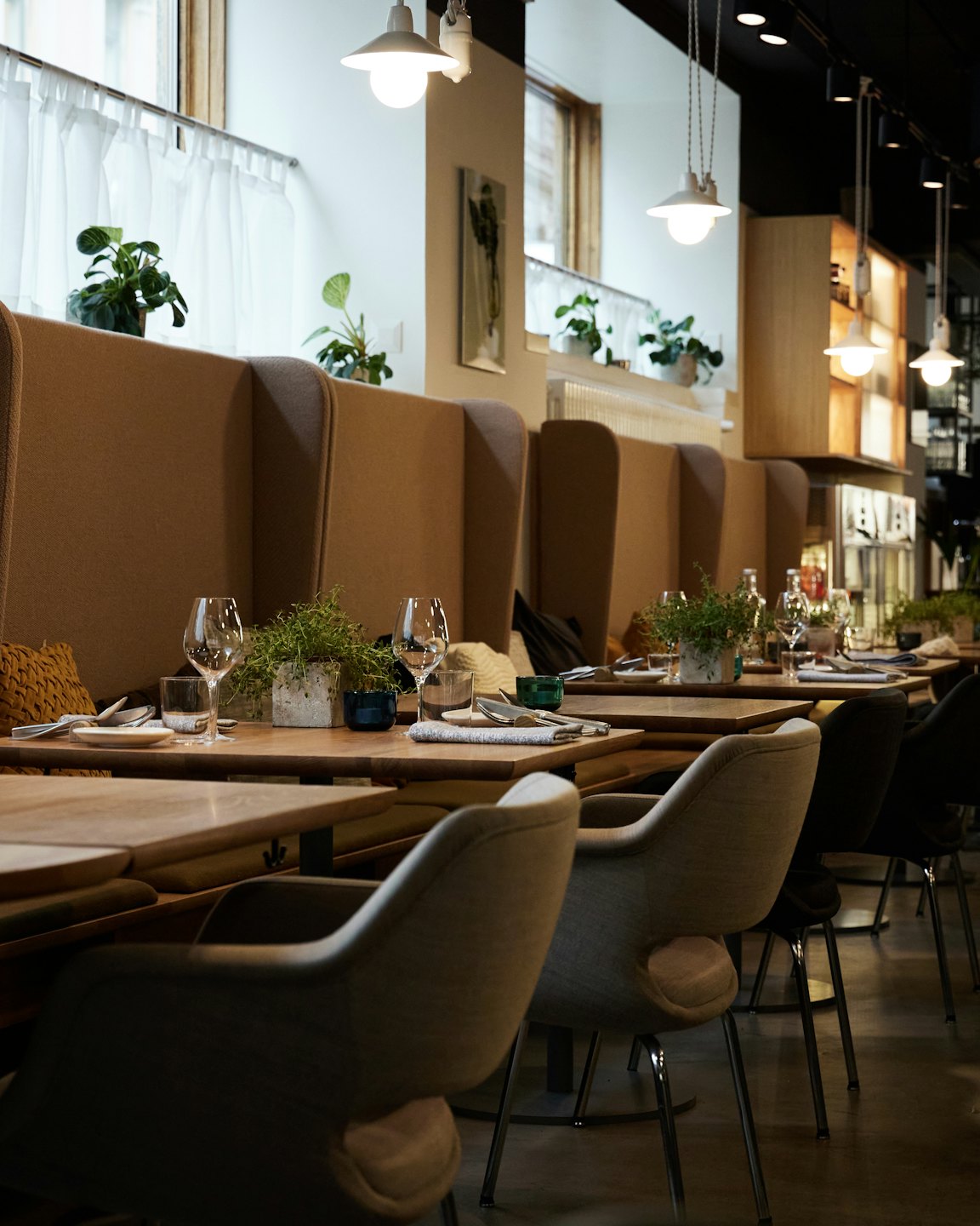Modern restaurant dining room with tan booth seating.