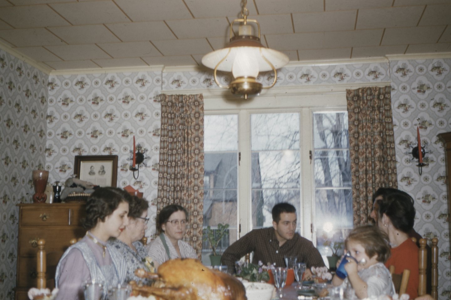 Multi-generational family enjoys a holiday meal around a dining table.