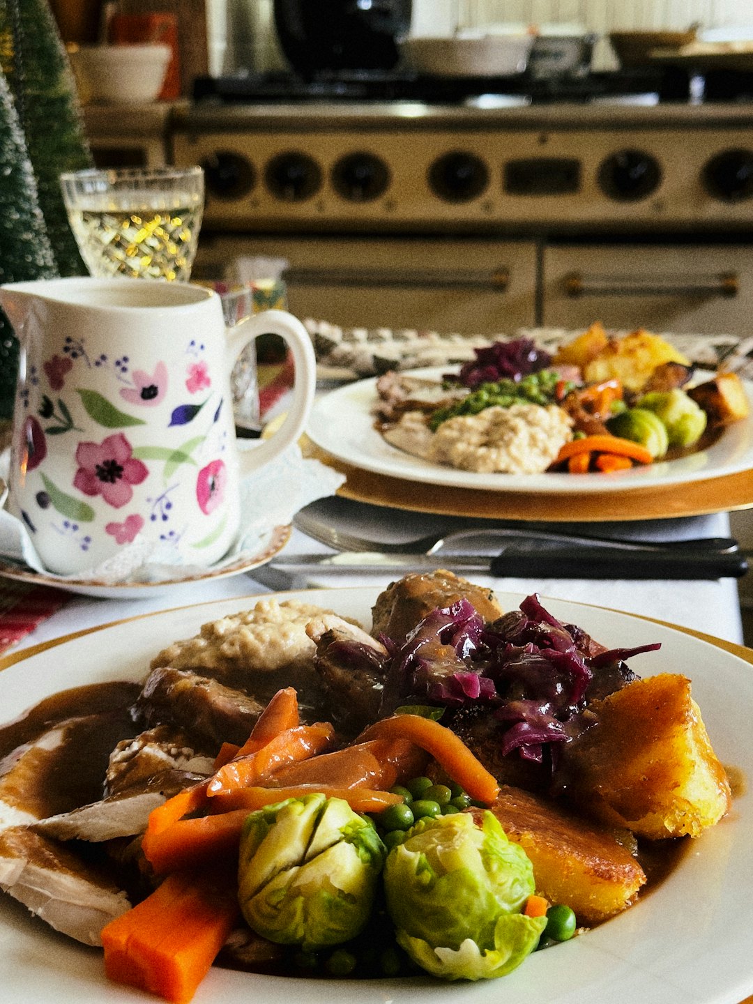 Roasted meat and vegetables served on two plates on a dining table.